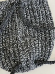 Nahaufnahme der grauen Strickkordel-Muetze, weicher Wolle-Stoff, Winter Mode Accessoire.