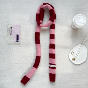 Detailed shot of Y2K pink dark red striped knit scarf, trendy long narrow scarf accessory.