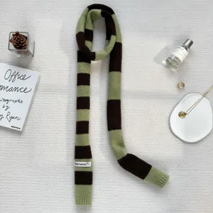 Details of a trendy Y2K green brown striped knitted long narrow scarf for autumn winter.