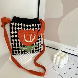 Gebreide schoudertas met leuk oranje tulp motief en stijlvolle zwart-witte ruitjes print.