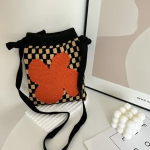 Gedetailleerd overzicht van de gebreide geruite schoudertas met een leuk oranje bloemenpatroon.