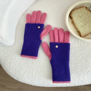 Detail view of the colorful knitted fingerless gloves showing soft wool texture and cute metal button.