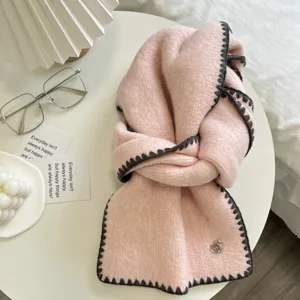 Cozy winter pink knitted scarf featuring dark grey contrast edge and cute heart charm.