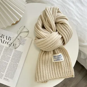 Gemütlicher, beige Strickschals-Detail mit weicher Rippenstruktur und einem Markenetikett.