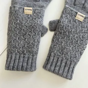 Graue Strickhandschuhe Detailansicht, weiche Zopfstrick-Textur mit Rippbündchen und Etikett.