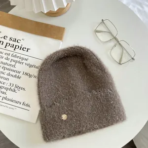 Cozy brown fuzzy knit beanie hat with metal accent, warm slouchy winter headwear for women.