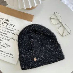 Chic winter black knit beanie with silver glitter, stylish metal charm and trendy flat lay details.