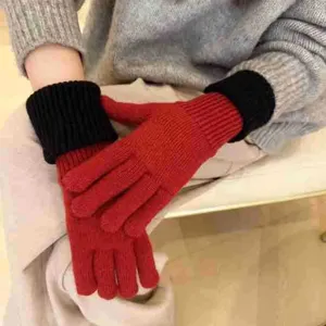 Detail shot of women's color-block knit gloves in red and black, showing texture and fit.