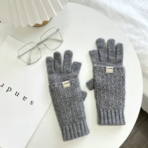 Graue Strick-Fingerlose Handschuhe mit Zopfmuster und Armband-Etikett für warme Wintertage.