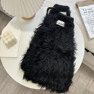 Vue détaillée de jambières duveteuses noires, texture tricot en fausse fourrure pour l'hiver.