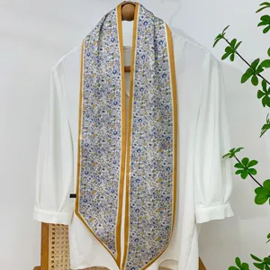 Detailed view of the elegant floral skinny scarf with gold border, perfect for bag or hair styling.
