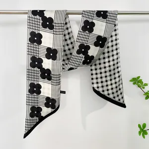 Detailed view of black and white floral houndstooth ribbon scarf, elegant neck wrap.