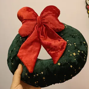 Weihnachtskranz Plüschkissen mit roter Schleife und goldenen Sternen, perfekte Dekoration.