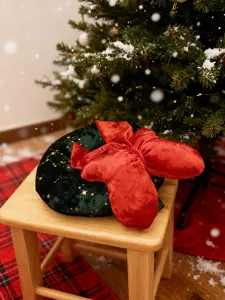 Weihnachtlicher Plüsch-Kranz-Kissen Detailansicht mit Goldsternen und roter Schleife.