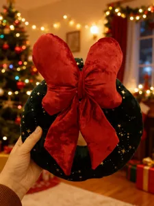 Detailansicht des weihnachtlichen Samtkranz Plüschspielzeugs mit großer roter Schleife, Festdeko.
