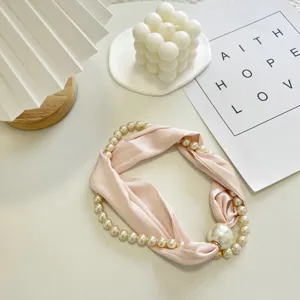 Elegante roze zijden sjaal ketting met delicate parelstrengen en chique magnetische sluiting.