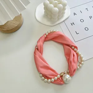 Gedetailleerd overzicht van de elegante roze zijden sjaalketting verweven met parels en magneet.