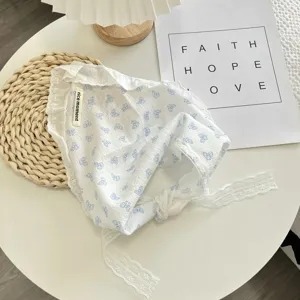 Detailed view of the French style white lace triangle headscarf with blue bow prints.