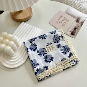 Dettaglio del fazzoletto quadrato floreale in cotone con delicato bordo in pizzo, stile vintage.
