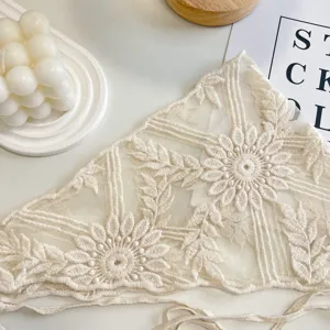 Dettaglio foulard triangolare in pizzo beige con ricamo floreale, fascia stile ins francese.