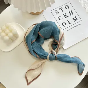 Close-up detail of the stylish crinkled square scarf featuring contrast color edging.