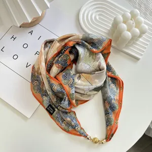 Detail shot of the spring silk square scarf with elegant swirl pattern and magnetic buckle.