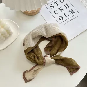 Detailed view of the pleated contrasting color small scarf tied neatly on white background setup.