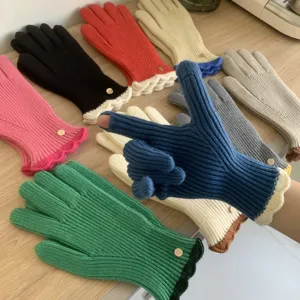 Primo piano dettagliato di guanti invernali in maglia colorati con graziosi polsini con volant.