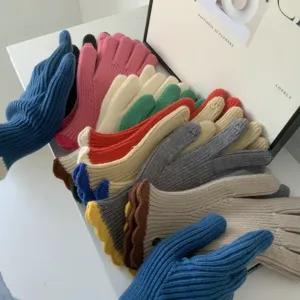 Dettaglio di guanti in maglia con eleganti volant elastici e calda consistenza invernale.