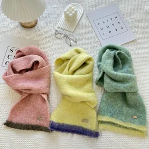 Gros plan détaillé d'écharpes en tricot bicolore douillettes en rose, jaune et vert.