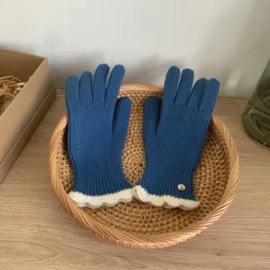 Guanti in maglia blu da donna con polsini con volant bianchi, caldo accessorio invernale.