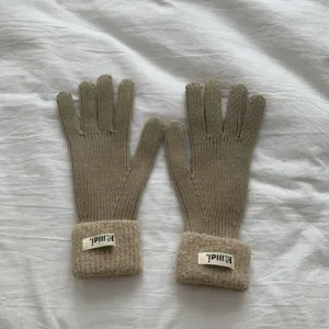 Detailed view of winter knit gloves, warm thickened split finger design with cozy ribbed cuffs.