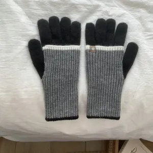 Detailed view of colorblock knit gloves with ribbed cuffs, warm winter accessories.
