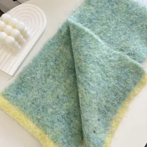 Gros plan sur la texture duveteuse de l'écharpe en tricot color-block, détail de tissu.
