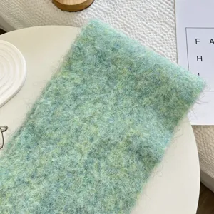 Détail d'écharpe en tricot vert confortable, texture laine douce, accessoire d'hiver chaud.