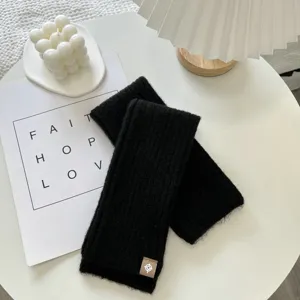 Detailed view of black knitted ribbed leg warmers, cozy autumn winter accessory texture.