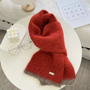 Écharpe tricotée rouge bicolore confortable avec étiquette métallique, accessoire chic.