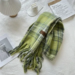 Detalle de bufanda de cuadros verdes con flecos textura suave y cálida para invierno acogedor.