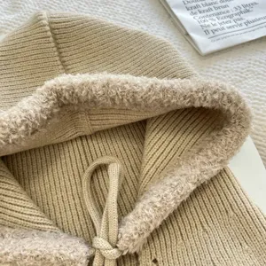 Knit hooded cap detail view, soft plush trim and warm fleece lining for winter wear.