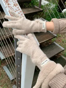 Gedetailleerde close-up van gebreide wollen handschoenen met schattige bontpompons.