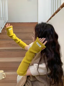Gros plan détaillé des chauffe-bras en tricot jaune avec une texture douce et chaleureuse.