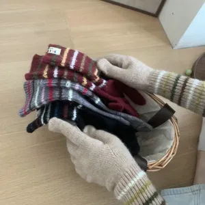 Detailaufnahme von koreanischen Strick-Handschuhen lang im Korb, warme Herbst Winter Accessoires.