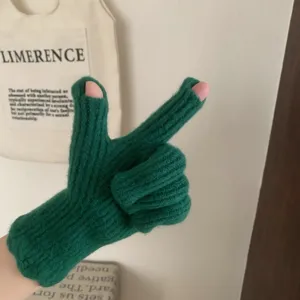 Gros plan sur les gants d'hiver tricotés vert foncé sans doigts, texture de laine douillette.
