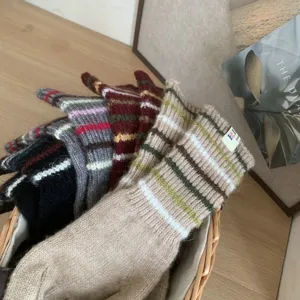 Gemütliche gestreifte lange Damenhandschuhe für den Winter, warme modebewusste Accessoires.
