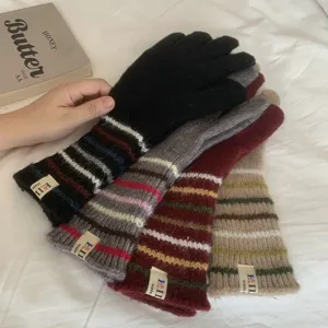 Nahansicht von warmen Damen-Strickhandschuhen mit Streifen, weicher Textur und schickem Label.