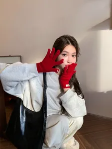 Cozy winter red knitted gloves for women, stylish five-finger warm thermal gloves for cold weather.
