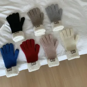 Close-up of cozy knit winter gloves with plush fleece cuffs in various assorted colors.