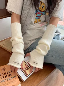 Gros plan sur les mitaines en tricot blanc douillet, montrant la texture douce et le style.