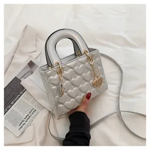 Silver heart quilted handbag for women, stylish top handle crossbody bag with gold charm.