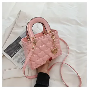 Pink glossy heart quilted handbag, detail view of cute top handle crossbody bag hardware.